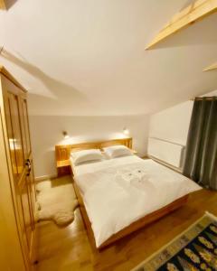 a bedroom with a large white bed in a room at Hirsch Chalet Apuseni in Mărgău