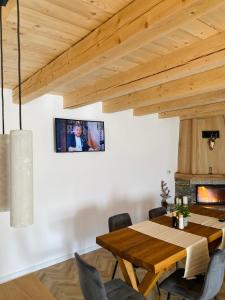 a dining room with a wooden table and a fireplace at Hirsch Chalet Apuseni in Mărgău