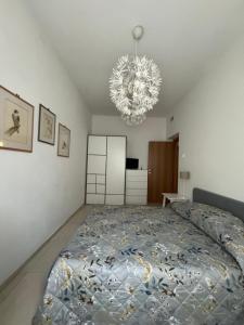 a bedroom with a large bed and a chandelier at Casa. Grassi in Siena +1 photo