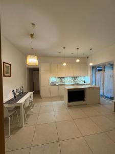 a large kitchen with white cabinets and a table and chairs at Casa. Grassi in Siena