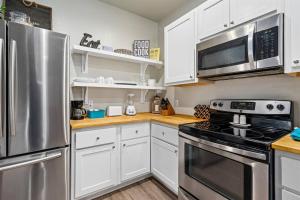 a kitchen with stainless steel appliances and white cabinets at The Yellow Getaway - Community Pool in Rockport