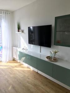 a living room with a flat screen tv on a wall at OstseeBrise - Sünnenkieker WE5 - ABC348 in Beckerwitz