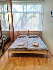łóżko w pokoju z dużym oknem w obiekcie Spacious apartment near old town w Wilnie