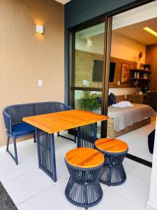 einen Tisch und zwei Hocker in einem Zimmer mit einem Bett in der Unterkunft Mana & Makia Slin Muro Alto in Porto De Galinhas