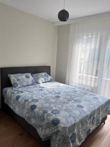 a bedroom with a bed with a blue quilt and a window at Allegro Apartments Kadıköy in Istanbul