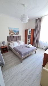 a bedroom with a large bed and a large window at Bursztynowa Przy Morzu - 1 minuta do plaży in Ustronie Morskie