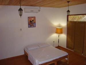 a bedroom with a bed and a lamp in it at La Serenado in Kataragama