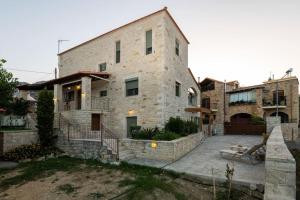 a large stone building with a courtyard in front of it at Quiet stone house near Plakias in Áyios Ioánnis