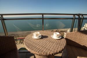 una mesa con 2 sombreros en la parte superior de un balcón en SeaGate en Batumi