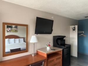 a hotel room with a bed and a mirror at University Inn Chico in Chico