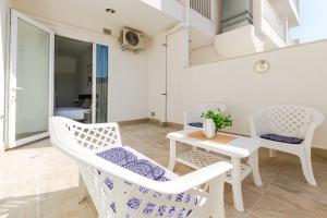 - un salon avec des chaises blanches et une table dans l'établissement Spacious Brand New Apartment 3 Bdr 2 Bth Large Terrace, à San Pawl il-Baħar