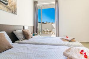 - 2 lits dans une chambre avec vue sur l'océan dans l'établissement Spacious Brand New Apartment 3 Bdr 2 Bth Large Terrace, à San Pawl il-Baħar
