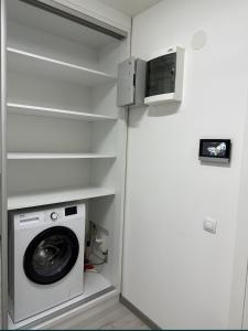 a washer and dryer in a room with a wall at Kate Studio in Galaţi