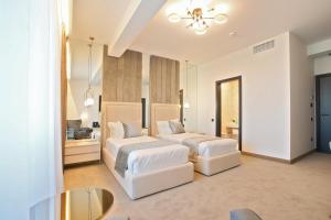 um quarto com 2 camas e uma mesa em Hotel Artemis em Oradea