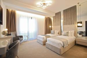 a hotel room with two beds and a bathroom at Hotel Artemis in Oradea
