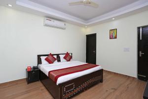 - une chambre avec un lit doté d'oreillers rouges dans l'établissement OYO Flagship Maira Homes, à Faridabad