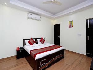 - une chambre avec un lit doté d'oreillers rouges dans l'établissement OYO Flagship Maira Homes, à Faridabad