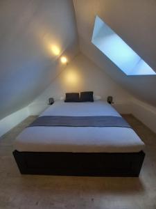 1 dormitorio con 1 cama grande y ventana en Les hauts de Meez, en Dinant