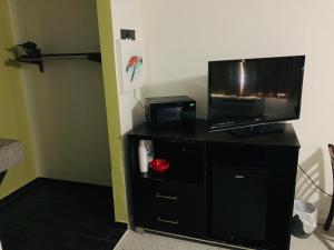 a tv on top of a black entertainment center at Suite With Pool Access in Davenport