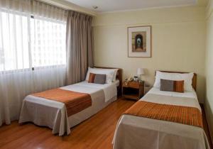 HOTEL DACARLO في سانتياغو: غرفة فندقية بسريرين ونافذة