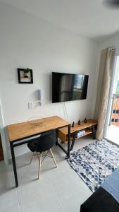 a living room with a desk and a tv at Ponte Laguna, Parque Burle Max in Sao Paulo