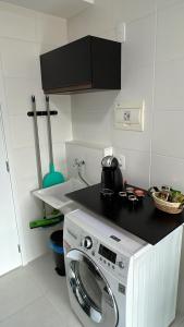 a kitchen with a washing machine on a counter at Ponte Laguna, Parque Burle Max in Sao Paulo