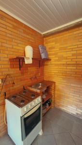 a kitchen with a stove and a sink at Pousada Parque da Cachoeira in São Francisco de Paula