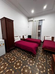 um quarto com duas camas com lençóis vermelhos em Hotel Nelson - Bab El Oued em Bab el Oued