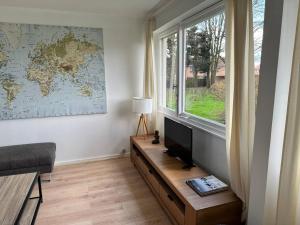 sala de estar con TV y ventana en Appartement Lumineux 3 chambres, en Marcq-en-Baroeul