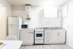 a kitchen with white appliances and white cabinets at Gente del Sur - Gobernador Paz in Ushuaia