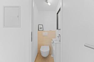 a white bathroom with a toilet and a sink at Wohlfühloase Flacht in Weissach