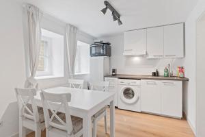 a white kitchen with a white table and chairs at Wohlfühloase Flacht in Weissach
