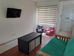 a living room with a tv and two chairs at La Casa de Milu in Chascomús