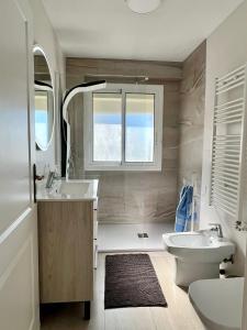 a bathroom with a sink and a toilet and a window at Bello Horizonte Apartman 4B in Salou