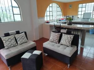 sala de estar con 2 sillas y cocina en 3 Cuarto independiente individual Ambato, en Ambato