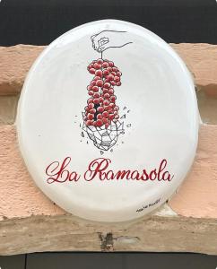 a sign with a bunch of grapes on a wall at La Ramasola in Fasano