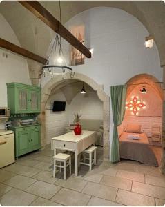 een keuken met een tafel en een kamer met een bed bij La Ramasola in Fasano