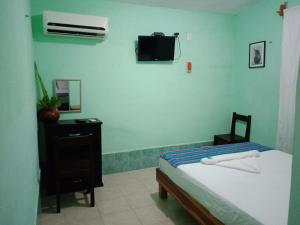 VeneciaにあるHospedaje Wotoch Aayinのベッドルーム1室(ベッド1台、壁掛けテレビ付)