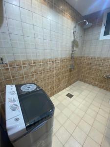 a bathroom with a toilet and a tiled shower at الرس in Al Rass