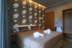 1 dormitorio con 1 cama con toallas en La Scogliera In, en Aci Castello