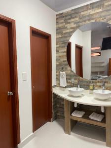 ein Badezimmer mit zwei Waschbecken und einem großen Spiegel in der Unterkunft HOTEL BOUTIQUE SIMACOTA in Simacota