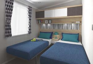 sypialnia z 2 łóżkami z niebieską pościelą i oknem w obiekcie Loch Lomond Holiday Park w mieście Inversnaid