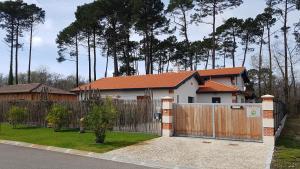 een wit huis met een hek en een hek bij Gite Villa Elisaia location de meublés de tourisme chez l'habitant in Arès