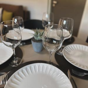 una mesa con copas de vino y platos en ella en SOMBRAS DEL PARANA Apart Misiones en Eldorado