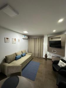 sala de estar con sofá y TV en SOMBRAS DEL PARANA Apart Misiones en Eldorado