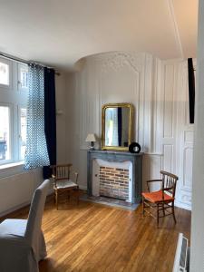 a living room with a fireplace and a mirror at Le Jean Jaurès in Troyes