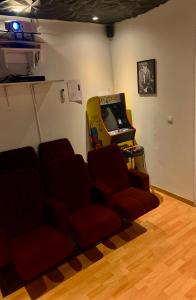 um quarto com uma consola de videojogos e cadeiras vermelhas em Chez Sophie em Altviller
