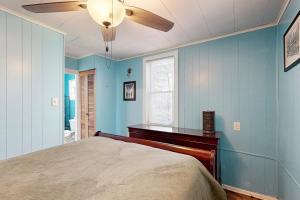 a blue bedroom with a bed and a ceiling fan at Alpine Dreams in Champion