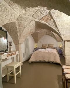 een slaapkamer met een bed, een tafel en een bureau bij La Ramasola in Fasano