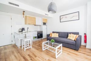 a living room with a couch and a kitchen at CARTAGENAFLATS, Apartamentos Anfiteatro Romano in Cartagena